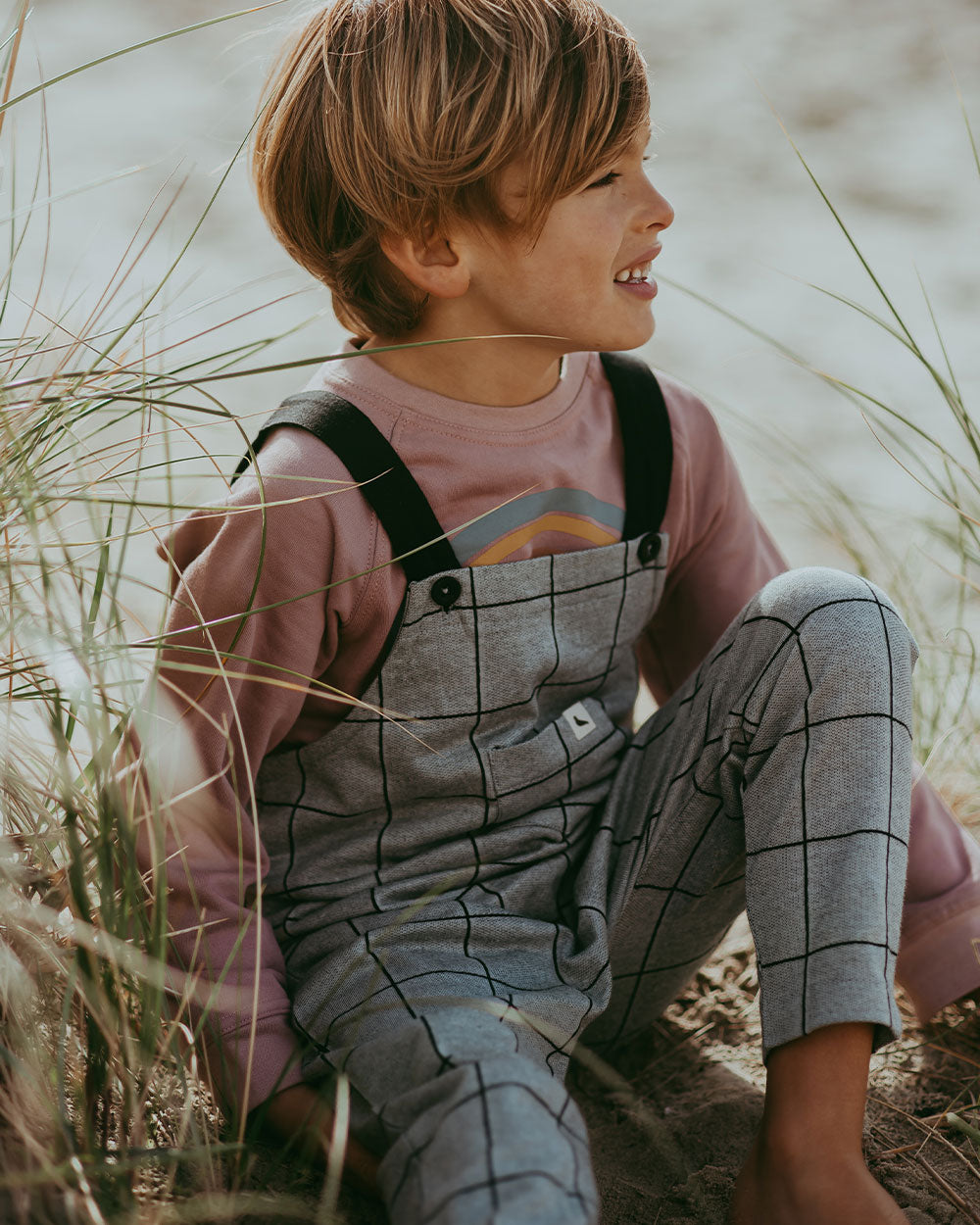 Boy wearing organic cotton grey pattern dungarees