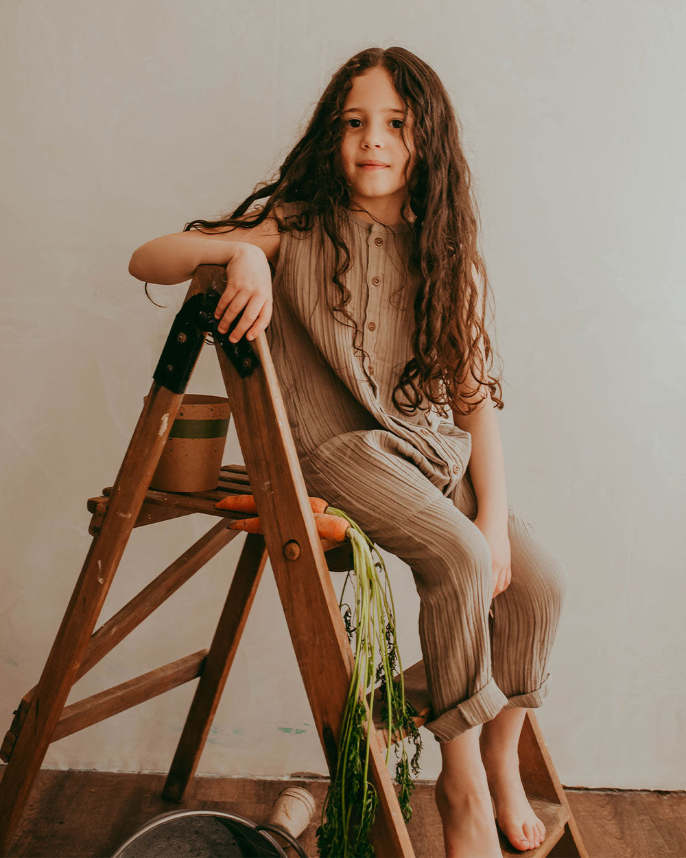 Girl wearing gender-neutral organic cotton kids dungarees