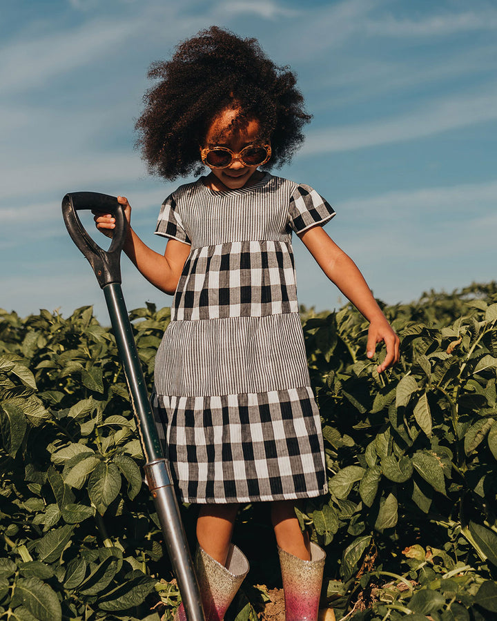 Girl wearing check stripe organic cotton kids dress
