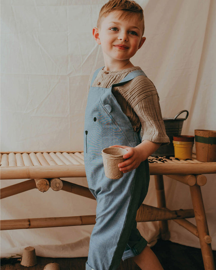 Boy wearing gender-neutral organic cotton short kids dungarees